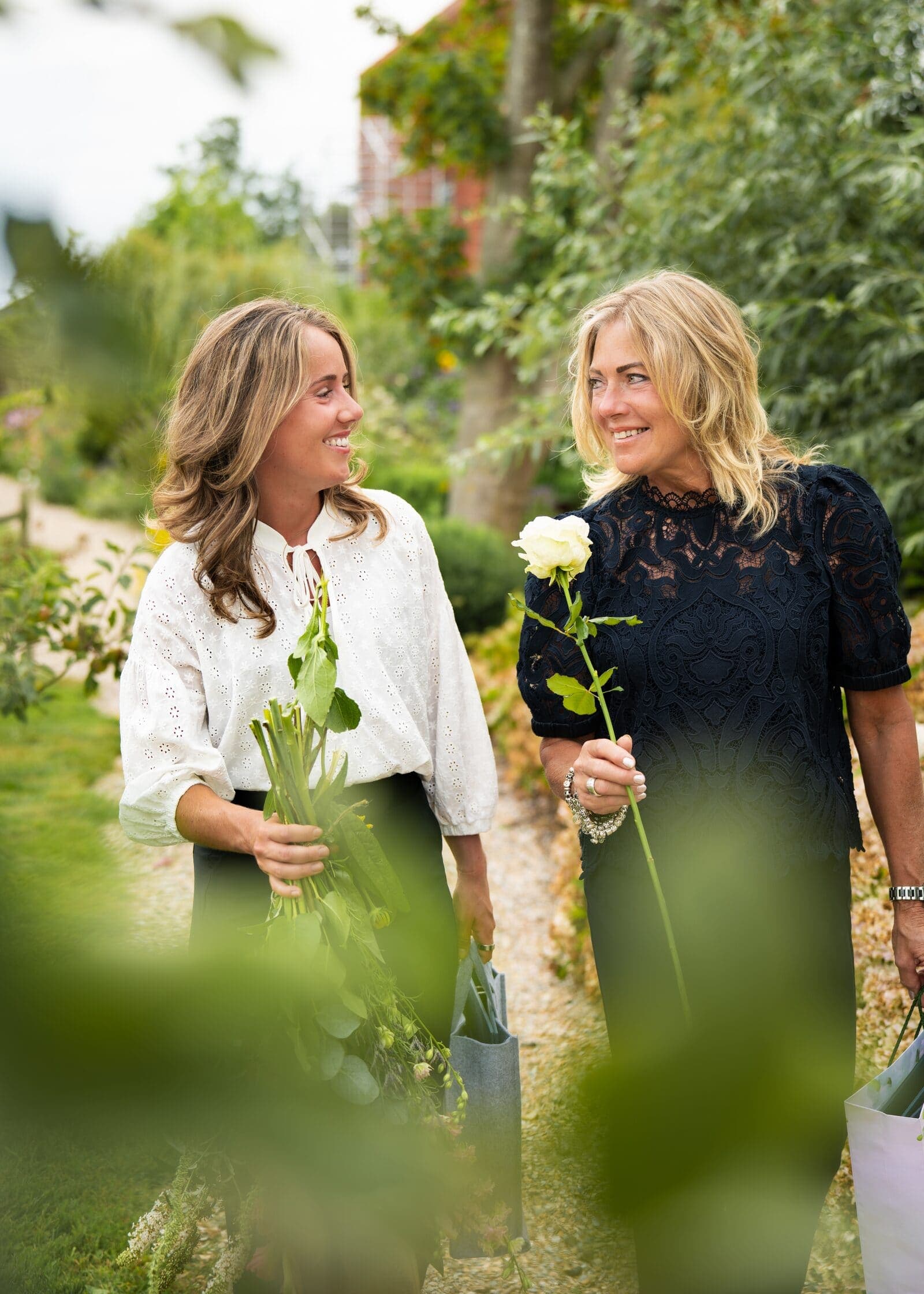 Twee collega’s met rozen in de tuin